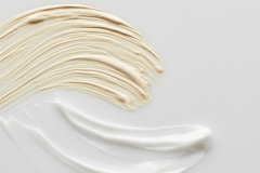 Top view of cosmetic and tone cream brushstrokes on grey background, panoramic shot