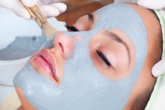 Girl with facial mask lying in beauty health spa center