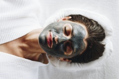 Woman relaxing with a charcoal facial mask