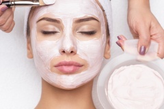 woman receiving  facial mask in spa beauty salon