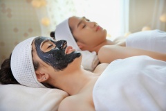 Young woman in black peeling face mask and girl friend, beauty concept