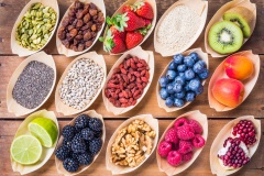 Healthy food, berries, fruits, nuts, seeds top view on rustic wood background.Healthy, detox, super food concept.