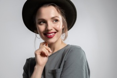 Stylish young beautiful woman with  red lips in casual black hat