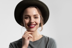 Close up portrait of stylish young woman in black hat smiling