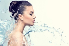 Beautiful model woman with splashes of water in her hands